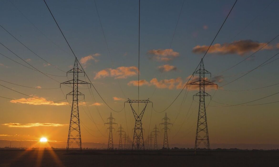Electricity pylons at sunrise OR sunset, unidentified location. Original public domain image from Wikimedia Commons